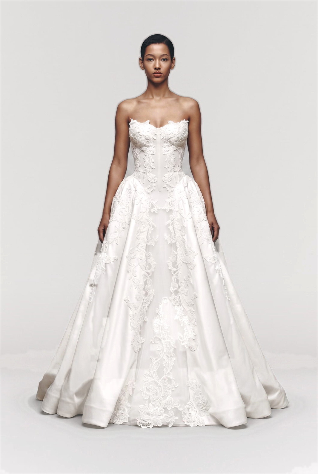 Bride in a strapless lace appliqué ball gown, full figure studio shot