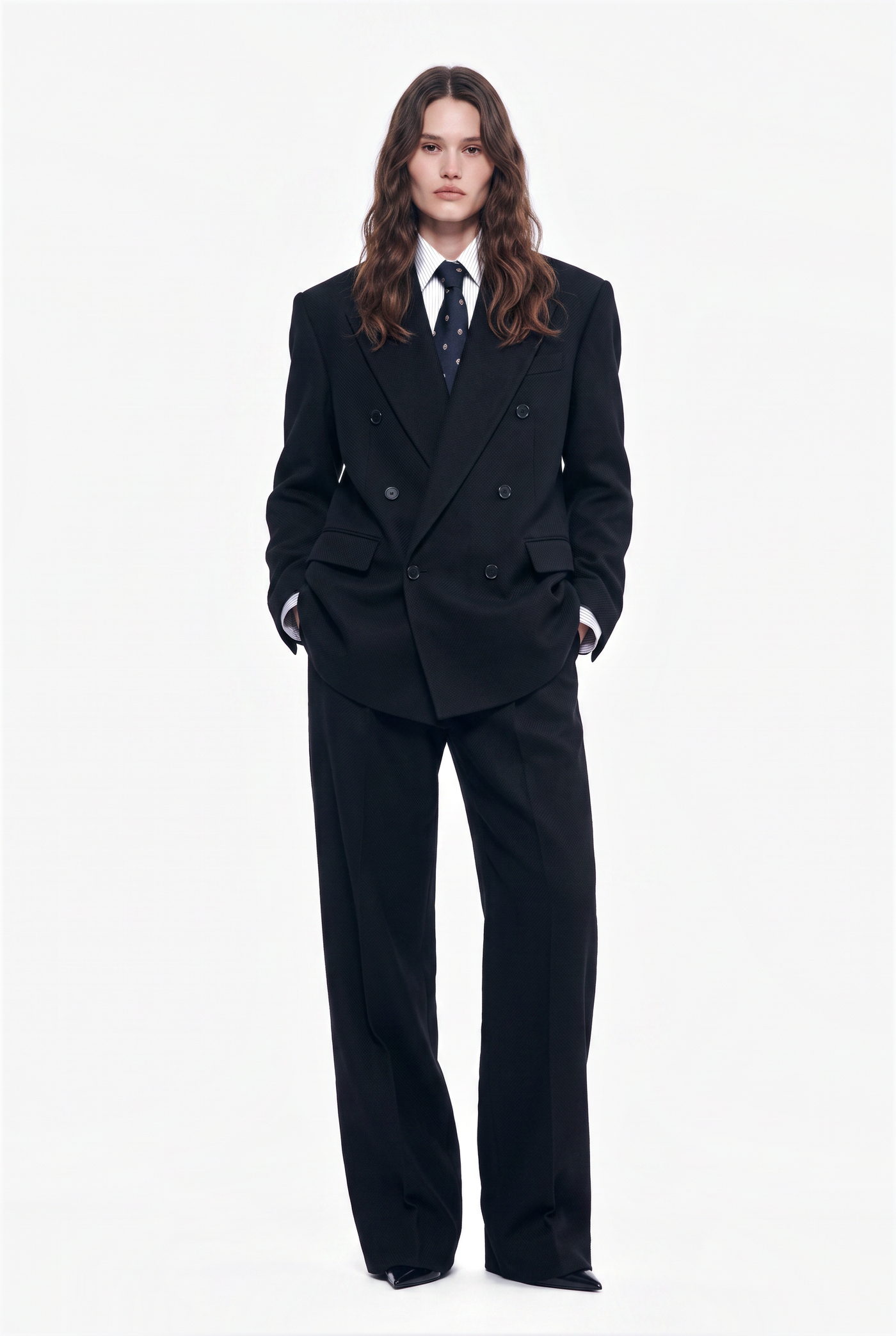 Woman in a navy double breasted suit with a shirt and tie