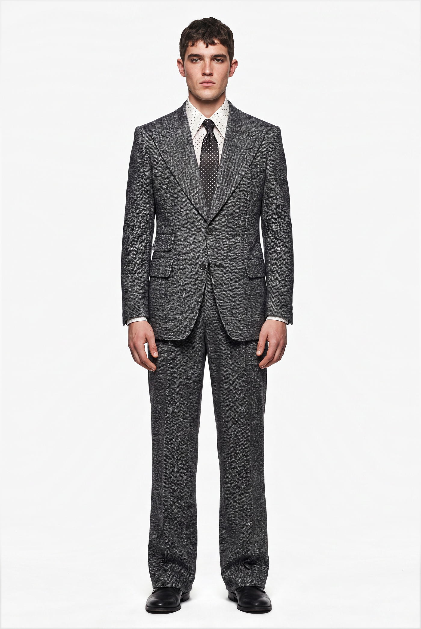 Man in a grey flecked wool suit with a patterned tie