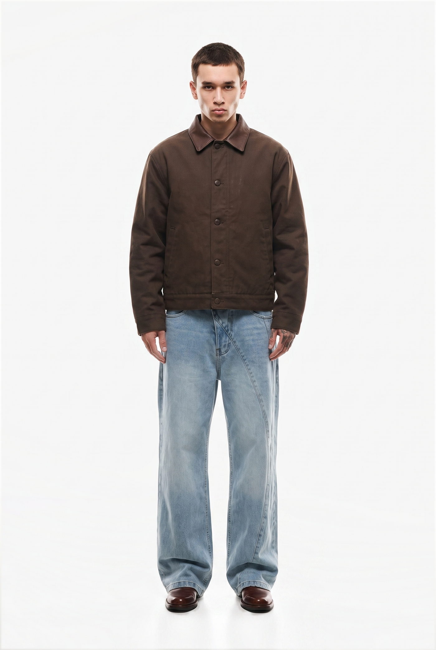 Man in a brown work jacket over a light wash denim and brown shoes