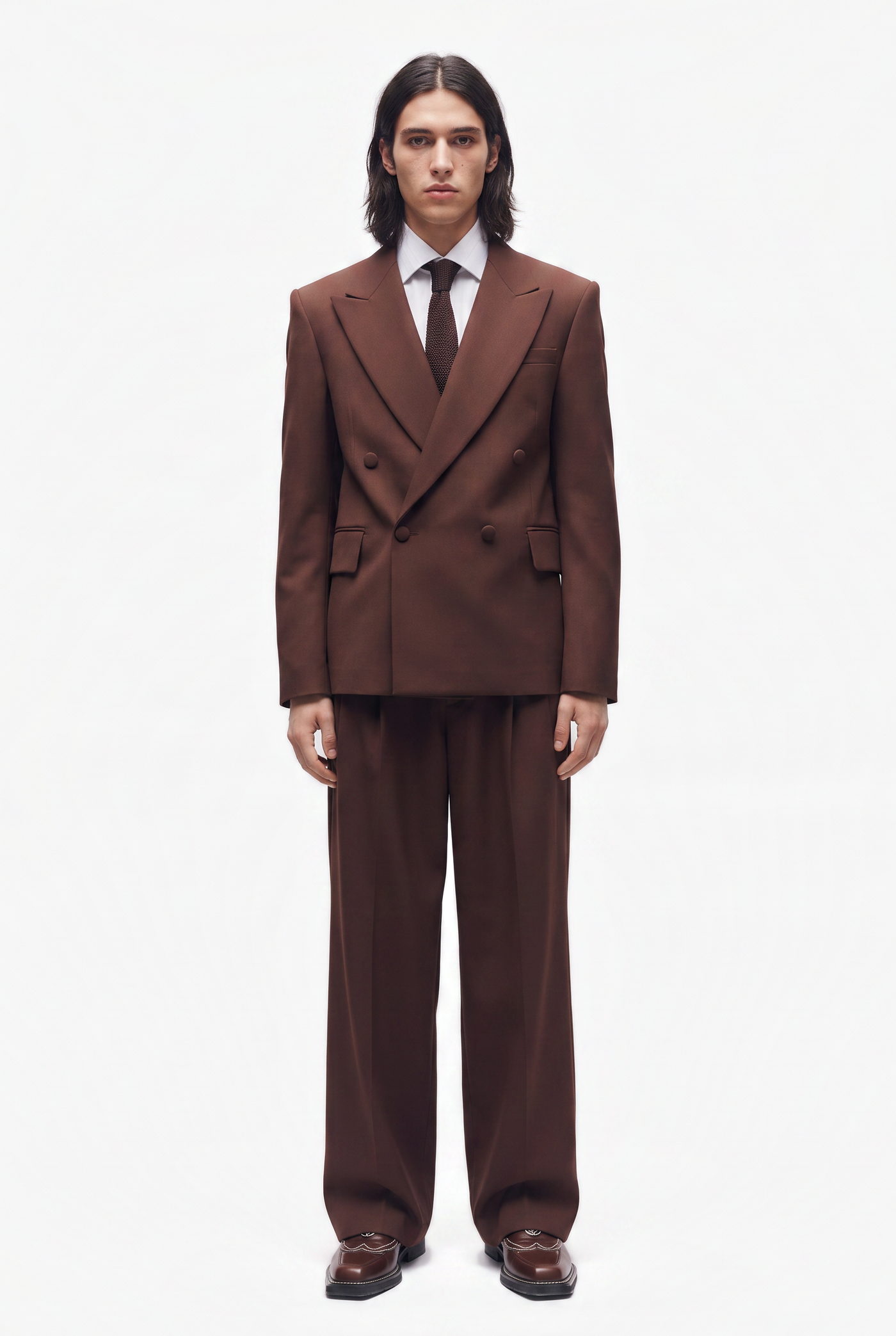 Man in a brown double breasted suit with a white shirt and dark tie