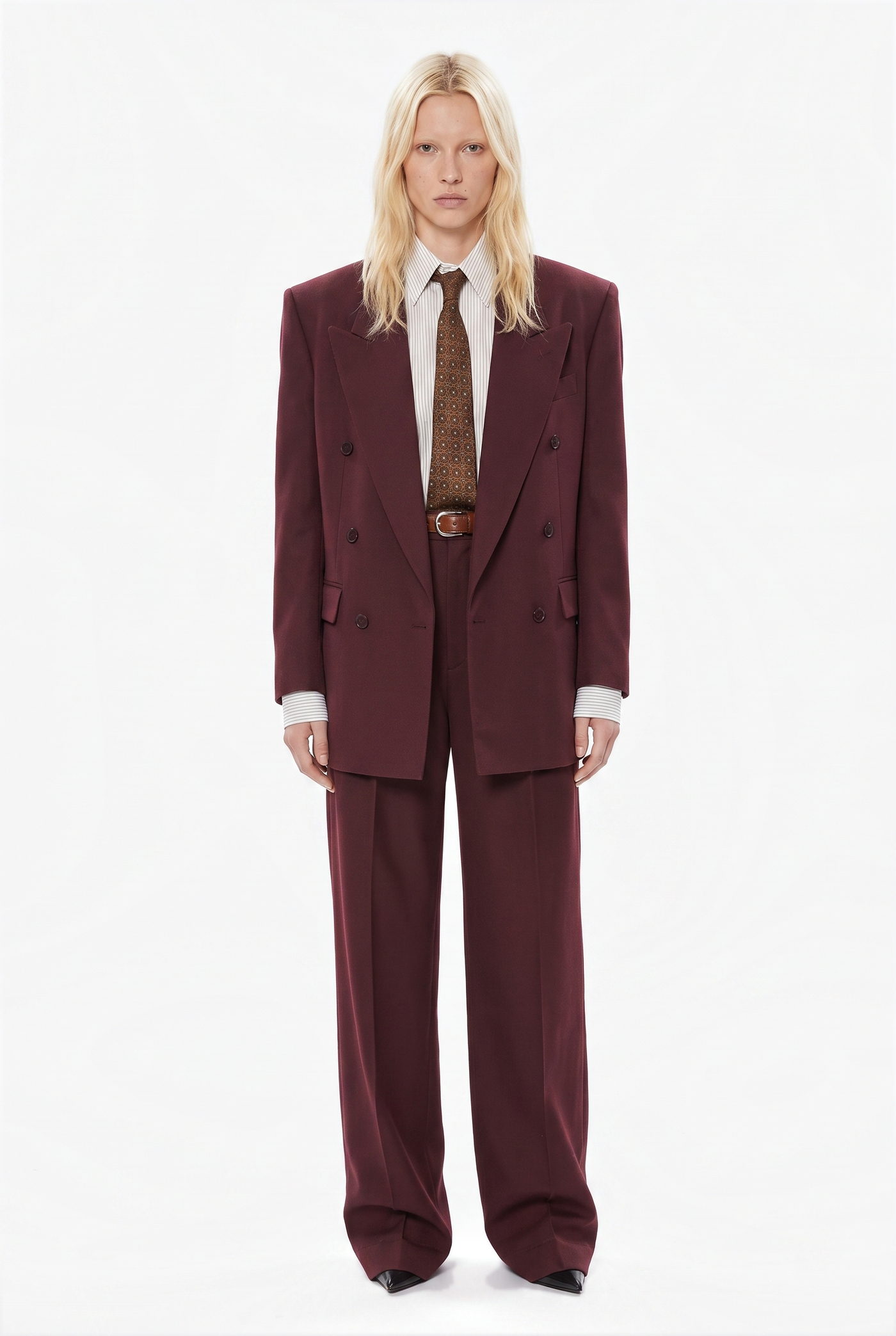 Woman in a burgundy double breasted suit with a patterned tie